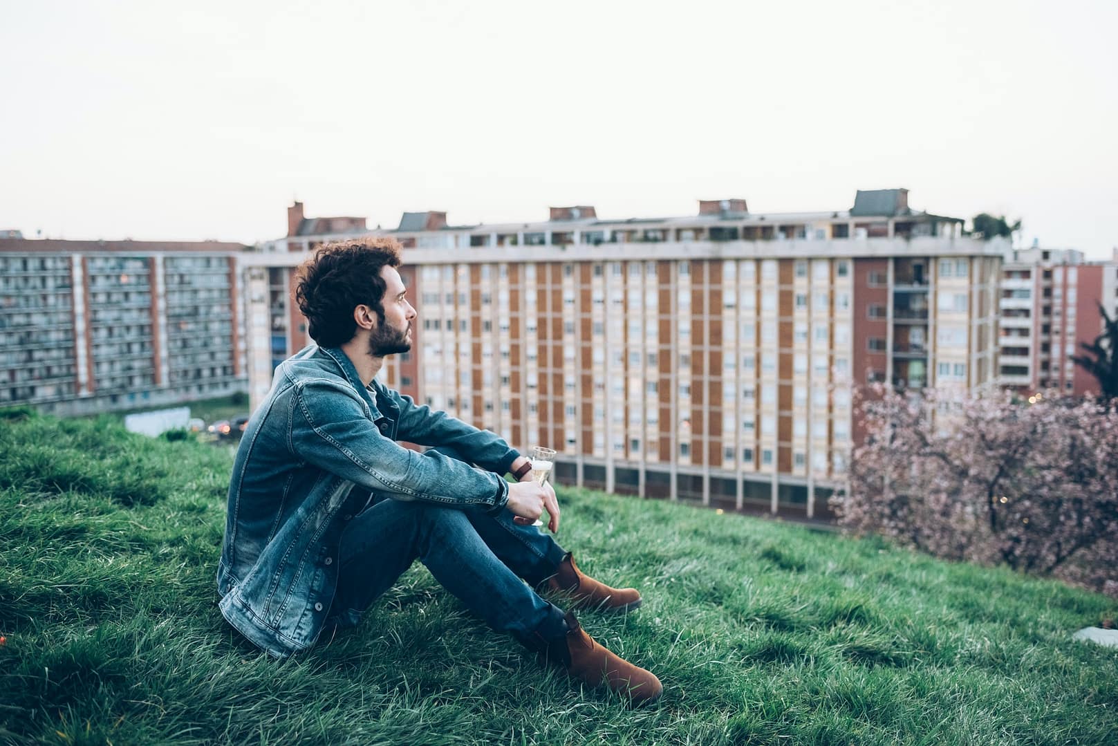 Young man sitting on rooftop garden, looking at view