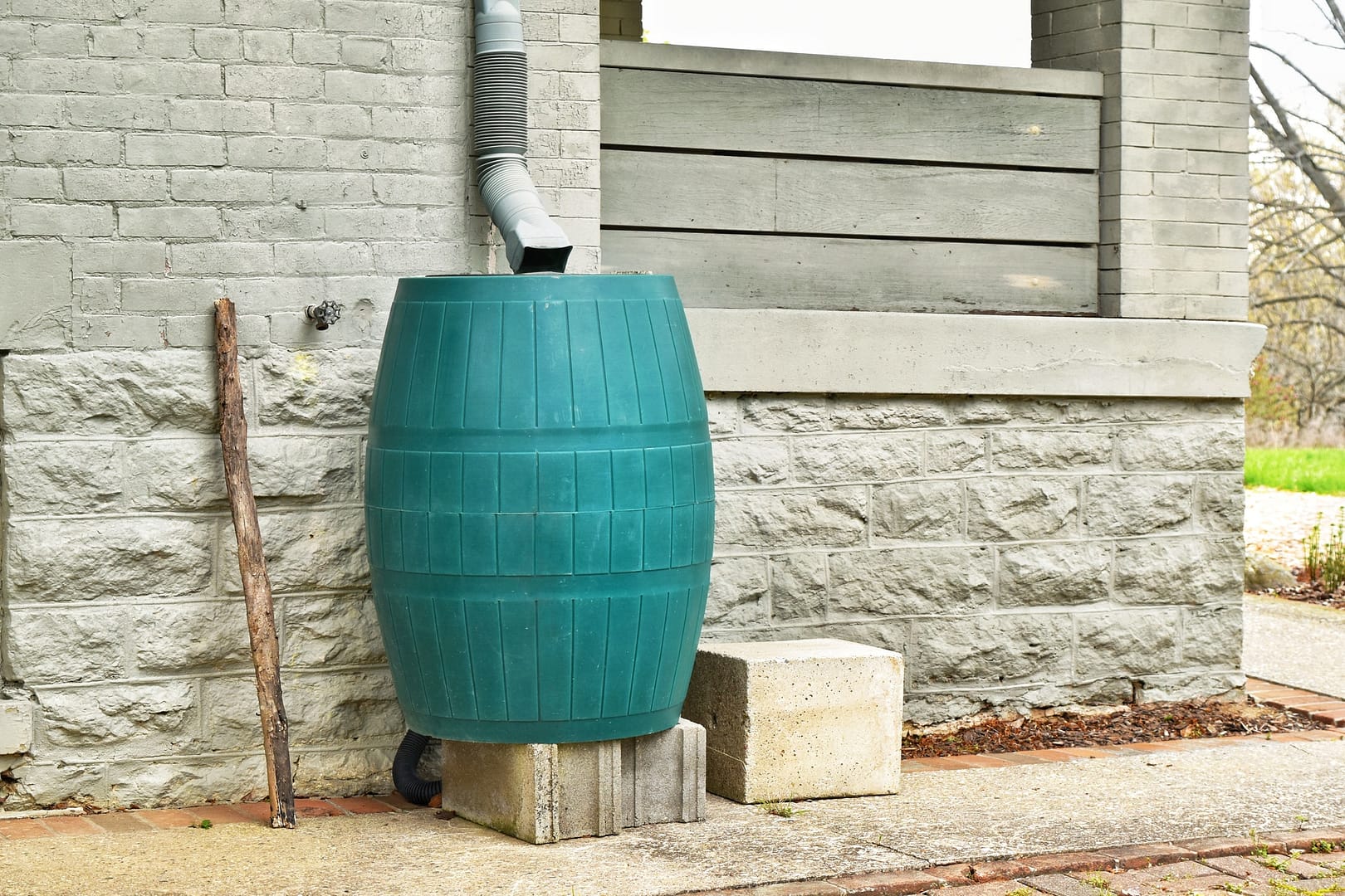 Green plastic rain catcher barrel to catch and conserve fresh chlorine-free water rainwater closeup