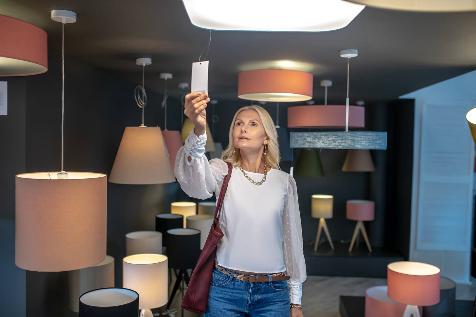 Woman is in the lighting department in a furniture store.