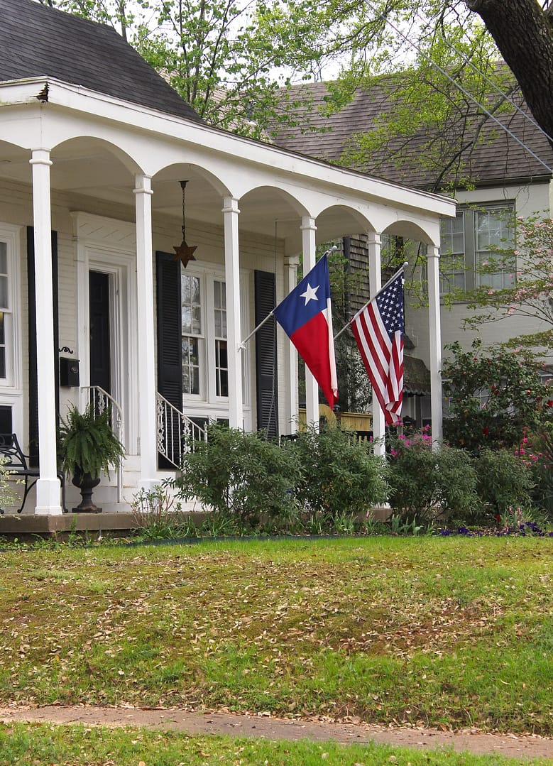 Historic Home With Texas and American Flags